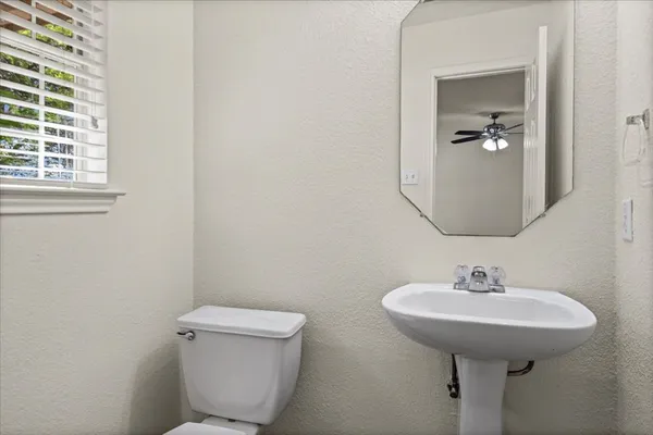 a bathroom with a toilet a sink and a mirror