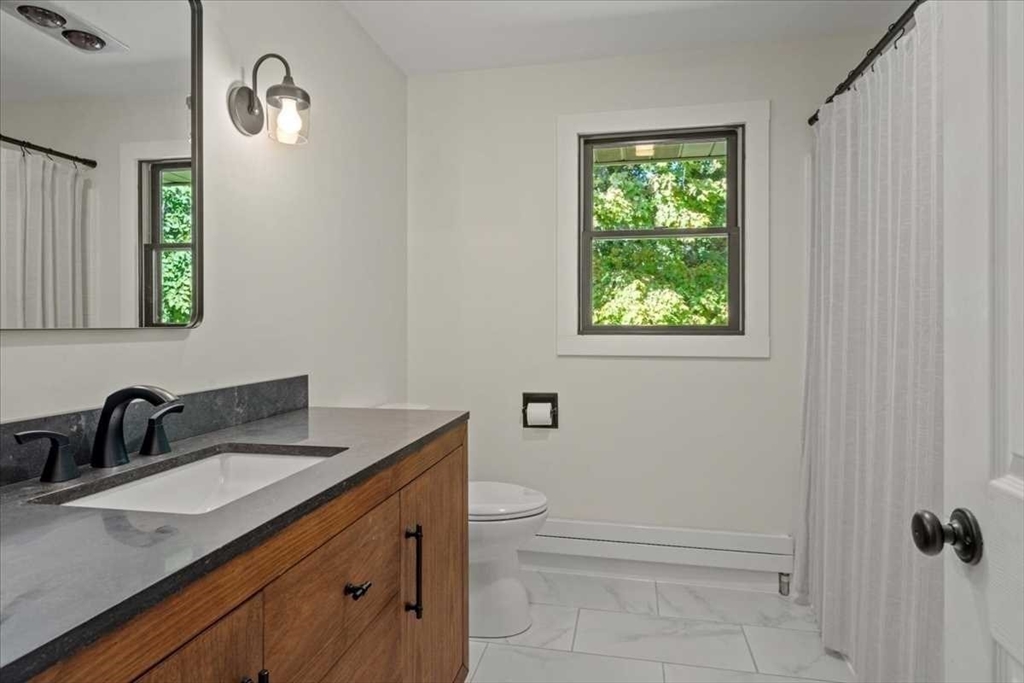26 West Temple Street Boylston, MA 01505 - Photo 25 of 42 a bathroom with a granite countertop sink toilet and a mirror