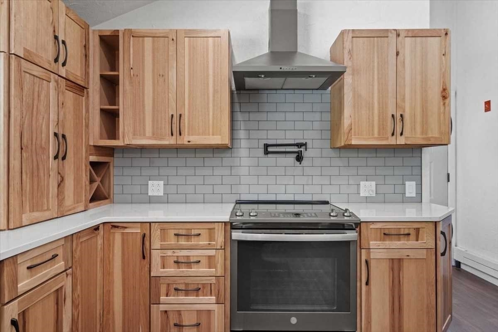 26 West Temple Street Boylston, MA 01505 - Photo 8 of 42 a kitchen with stainless steel appliances wooden cabinets and a stove top oven