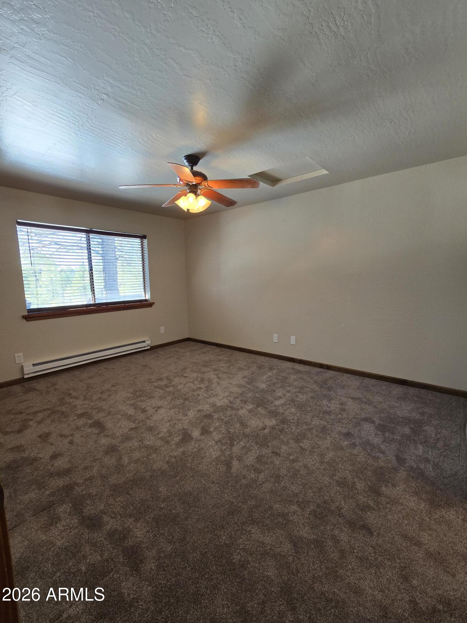 2795 Coyote Ridge Happy Jack, AZ 86024 - Photo 12 of 31 an empty room with windows and chandelier fan