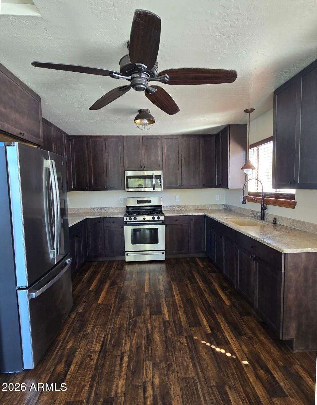 2795 Coyote Ridge Happy Jack, AZ 86024 - Photo 5 of 31 a kitchen with stainless steel appliances granite countertop a refrigerator a sink dishwasher a stove and white countertops with wooden floor