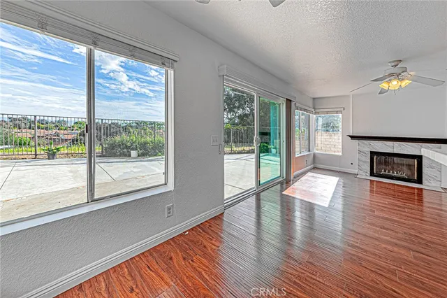a view of empty room with wooden floor and fireplace