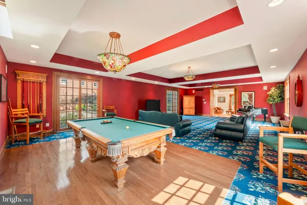 a living room with couches and dining table with wooden floor