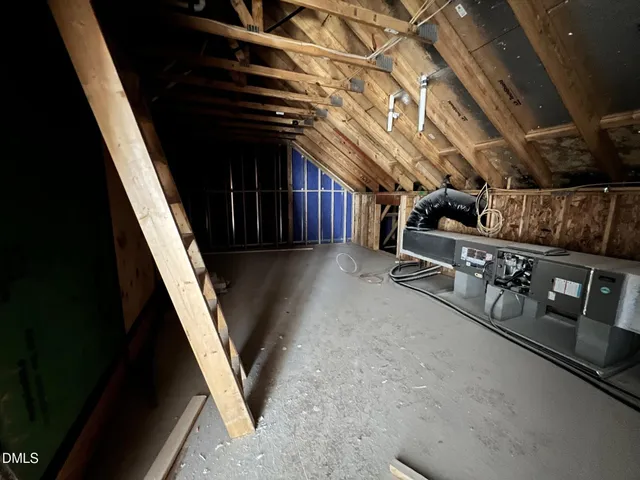 an empty room with wooden floor fireplace and windows
