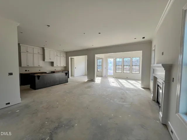 an empty room with windows and fireplace