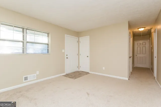 an empty room with windows and closet