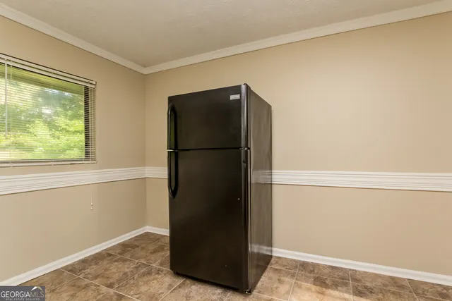 a view of a refrigerator in an empty room