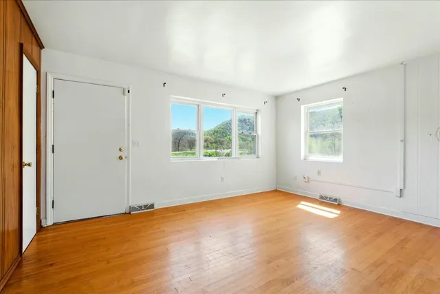 a view of empty room with wooden floor