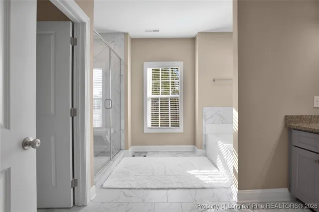 a en suite bathroom with a granite countertop sink and a mirror