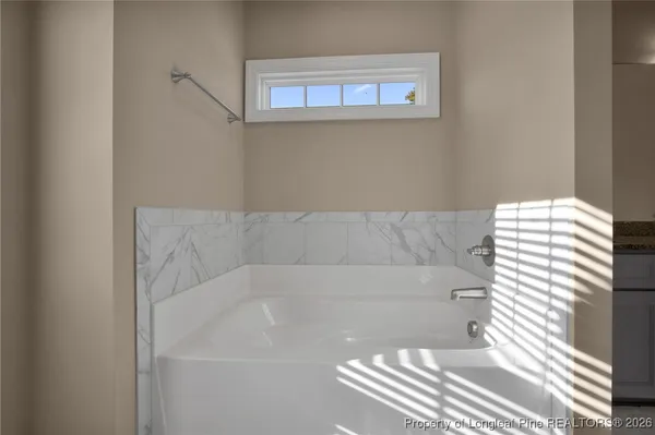 a bedroom with a large bed and a chandelier fan