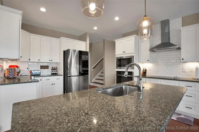 a white toilet sitting next to a bathroom sink vanity and granite