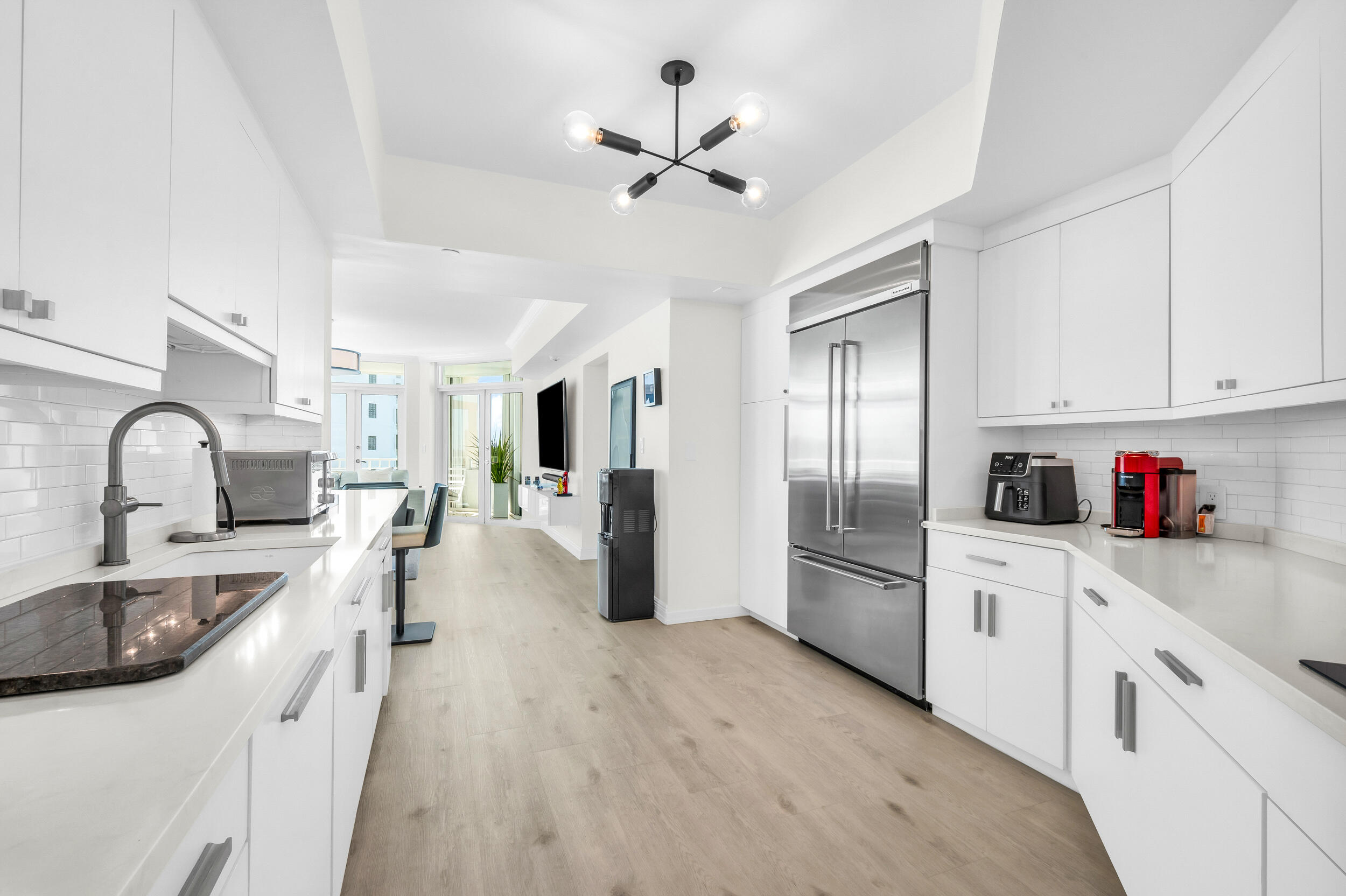 300 Southeast 5th Avenue, Unit 6110 Boca Raton, FL 33432 - Photo 5 of 96 a large kitchen with stainless steel appliances granite countertop a refrigerator a stove a sink dishwasher and white cabinets with wooden floor