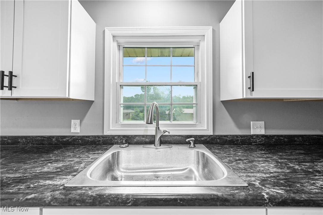 23595 Sandy Creek Road Minerva, OH 44657 - Photo 4 of 32 Kitchen view of a sink, white cabinets, and dark stone counters