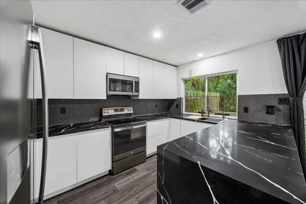 a kitchen with a sink stove and microwave