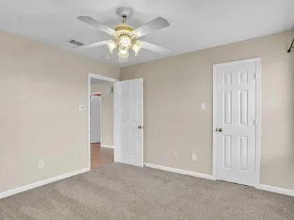 a view of an empty room with a chandelier fan