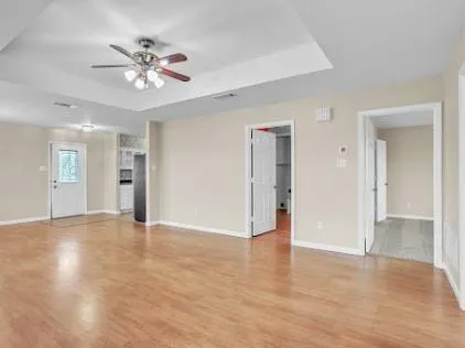 a view of an empty room with a chandelier fan
