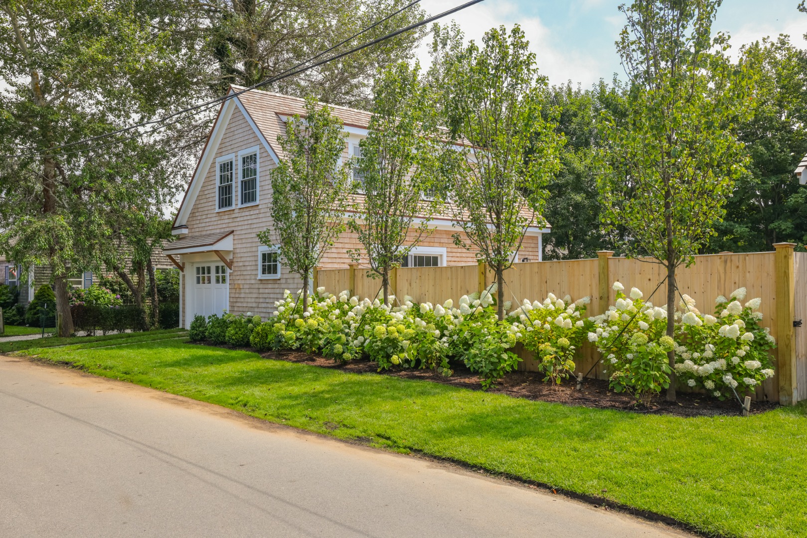 12 Derrymore Road Nantucket, MA 02554 - Photo 6 of 35 a view of a brick house with a big yard and large trees
