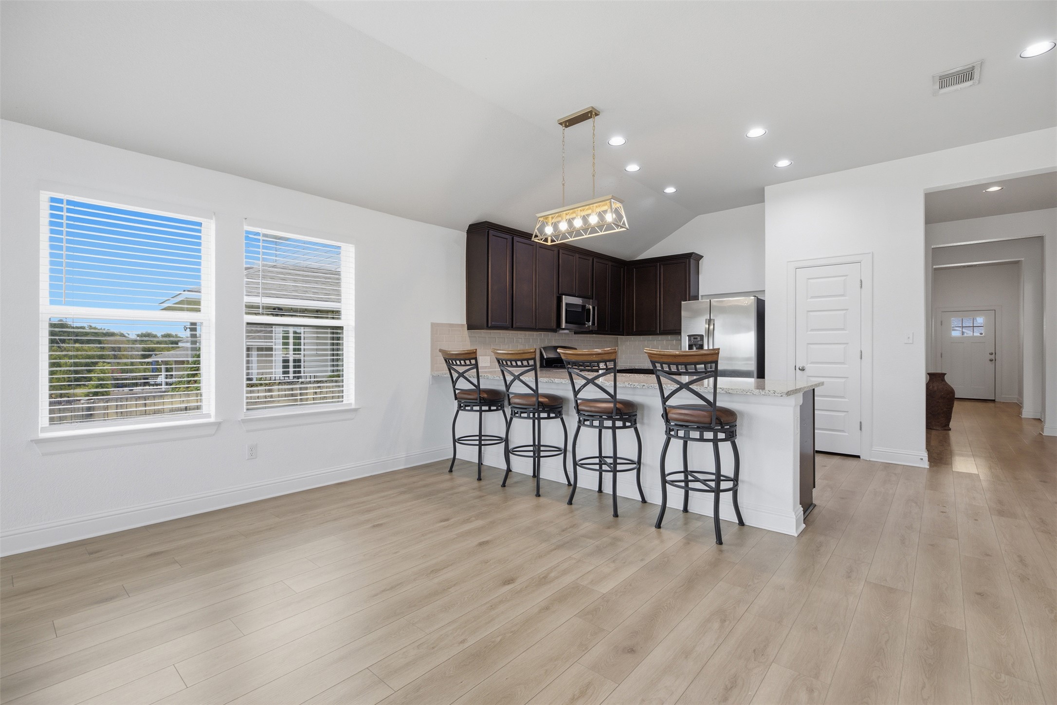 321 Gaida Loop Georgetown, TX 78628 - Photo 13 of 26 Gleaming wood floors anchor a wide-open breakfast area connecting seamlessly to the modern kitchen.