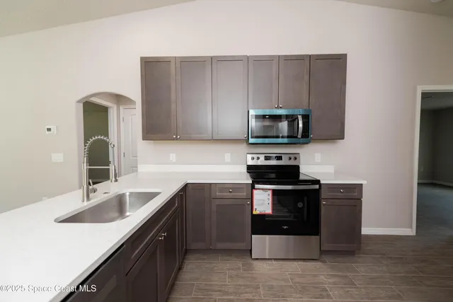 a kitchen with stainless steel appliances granite countertop a sink stove and microwave