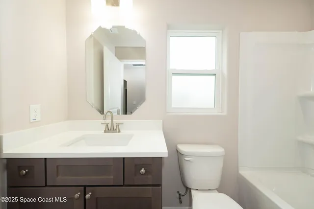 a bathroom with a sink toilet and mirror