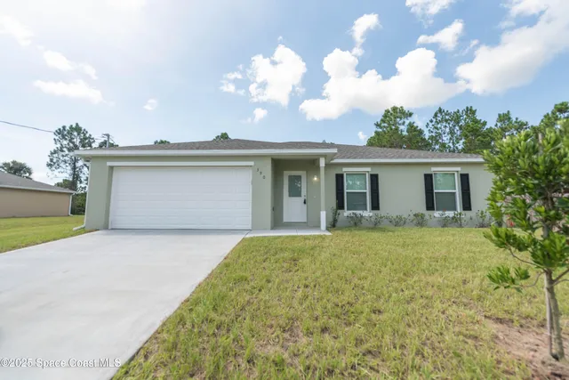 a view of a house with a yard and garage