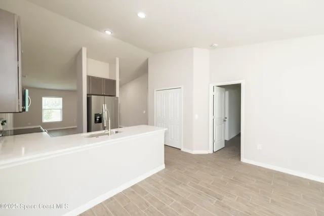 a living room with a sink and a refrigerator