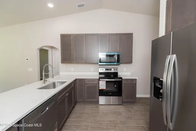a kitchen with stainless steel appliances granite countertop a refrigerator and a sink