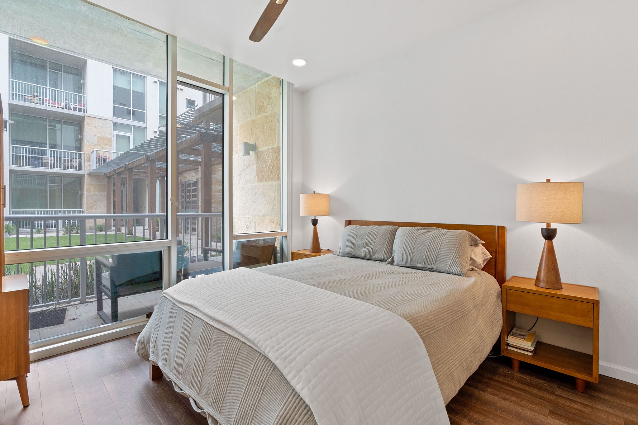 1600 Barton Springs Road, Unit 2102 Austin, TX 78704 - Photo 14 of 37 a bedroom with a large bed and a lamp next to a window