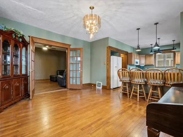 a kitchen with kitchen island a large counter top space a sink appliances and a chandelier