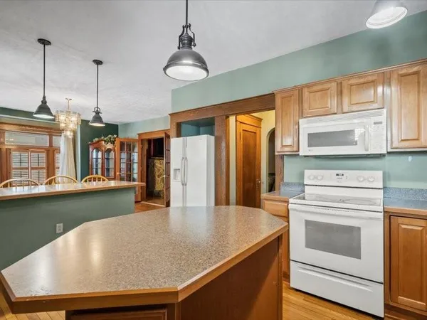 a kitchen with granite countertop a sink and dishwasher with wooden floor