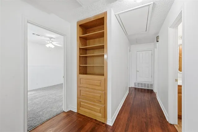 a view of a hallway with wooden floor and closet