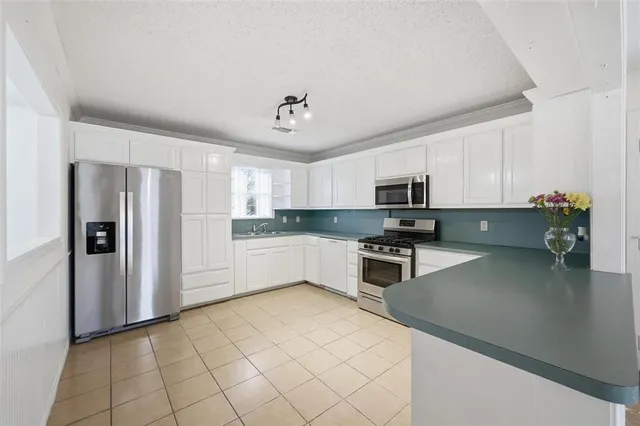 a kitchen with stainless steel appliances a refrigerator sink and microwave