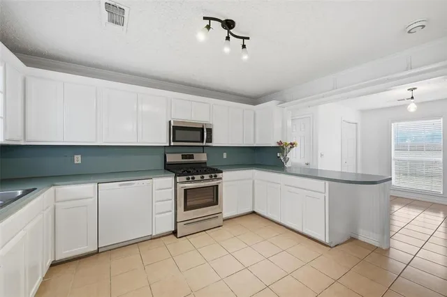 a kitchen with white cabinets stainless steel appliances and sink