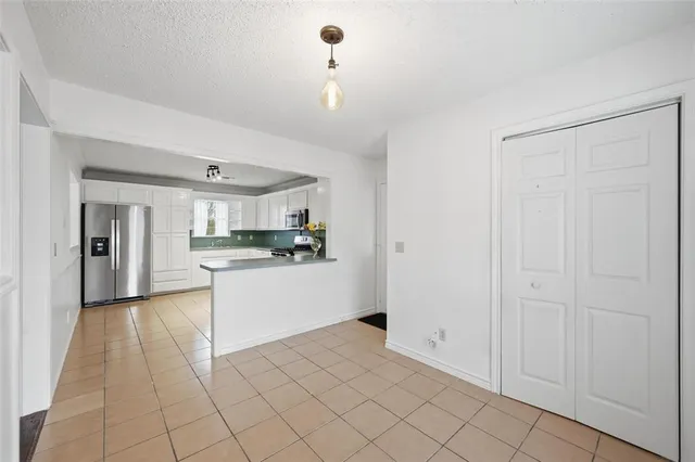 a kitchen with white cabinets and appliances