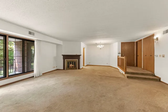 a view of an empty room with a fireplace and a window