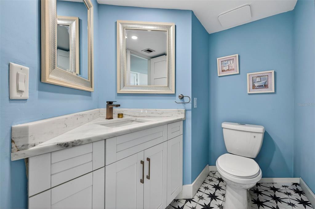 690 Island Way, Unit 1109 Clearwater Beach, FL 33767 - Photo 24 of 37 a bathroom with a toilet sink and mirror