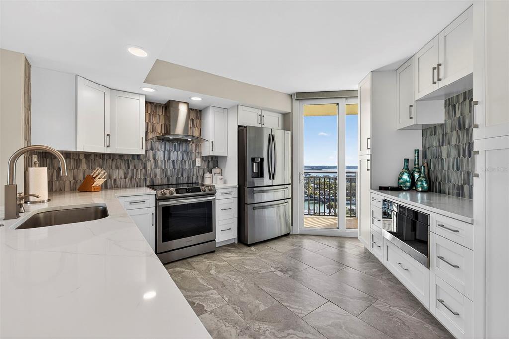 690 Island Way, Unit 1109 Clearwater Beach, FL 33767 - Photo 6 of 37 a kitchen with stainless steel appliances a refrigerator sink and stove