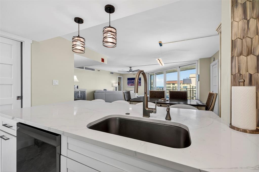 690 Island Way, Unit 1109 Clearwater Beach, FL 33767 - Photo 8 of 37 a kitchen with a sink dishwasher a stove and a refrigerator with wooden floor