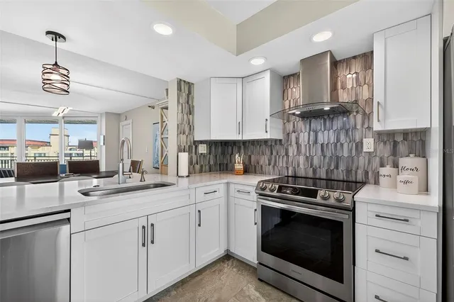 a kitchen with white cabinets and appliances