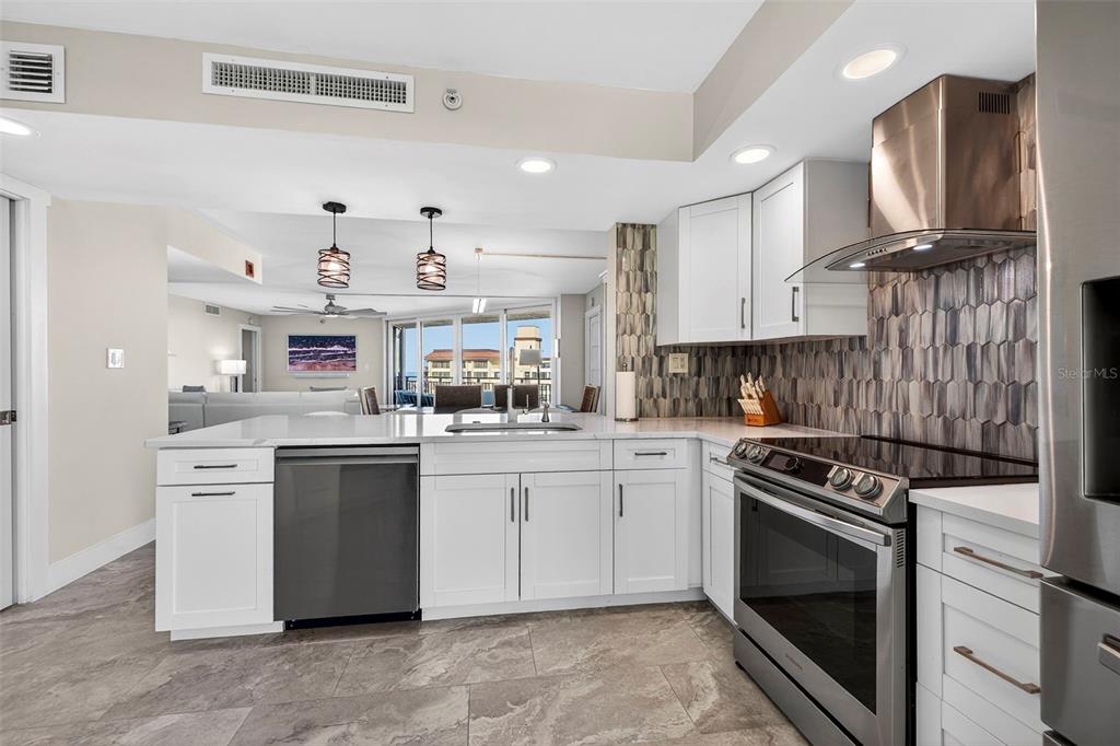 690 Island Way, Unit 1109 Clearwater Beach, FL 33767 - Photo 10 of 37 a kitchen with granite countertop cabinets stainless steel appliances and a counter space