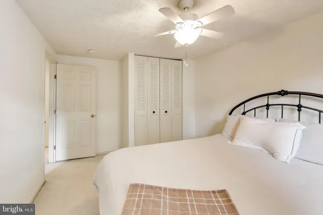 a bedroom with a bed and a ceiling fan
