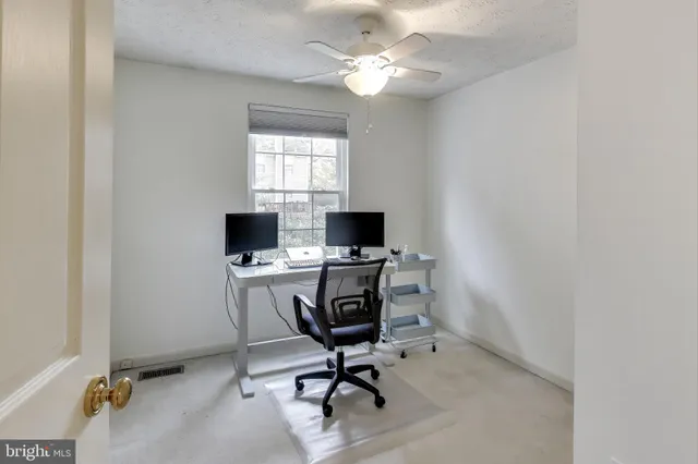 a view of a workspace with furniture and a window