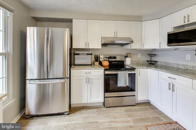 a kitchen with stainless steel appliances granite countertop a refrigerator stove a sink and a microwave