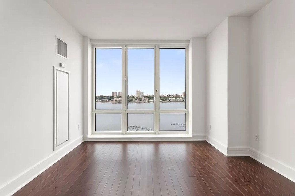 60 Riverside Boulevard, Unit 1707 Manhattan, NY 10069 - Photo 4 of 20 wooden floor in an empty room with a window