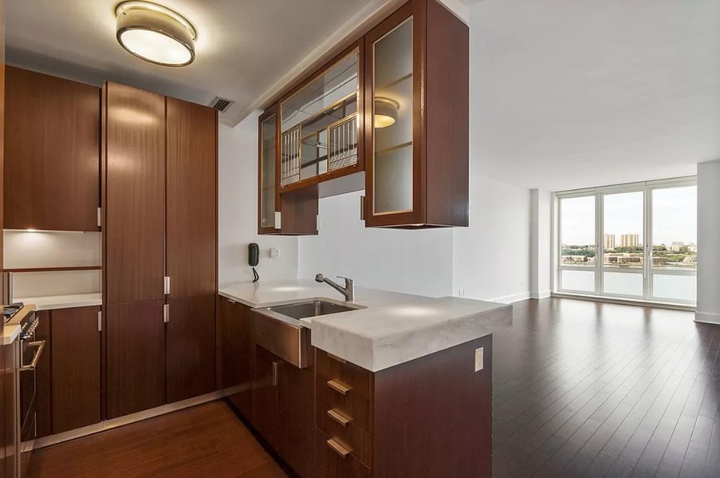 60 Riverside Boulevard, Unit 1707 Manhattan, NY 10069 - Photo 6 of 20 a kitchen with a sink and a refrigerator