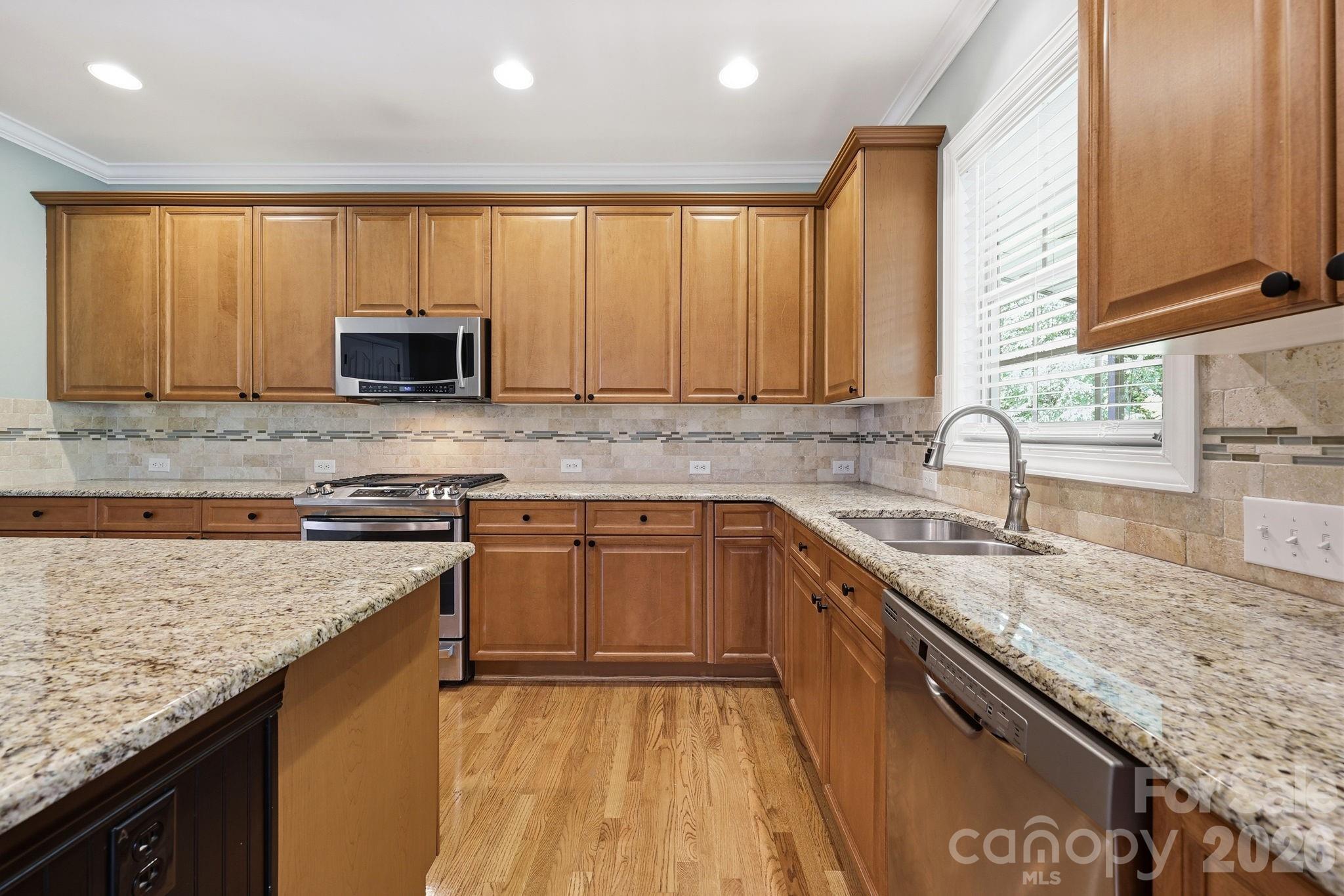 3308 Grandeur Road Charlotte, NC 28269 - Photo 16 of 45 a kitchen with kitchen island granite countertop a sink stove and cabinets