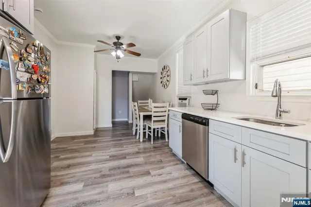 a kitchen with cabinets stainless steel appliances and a window
