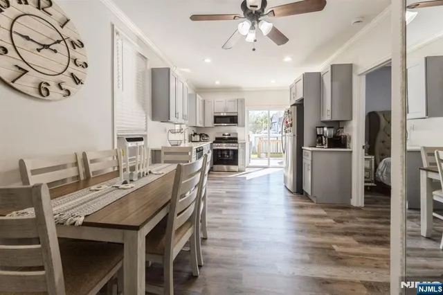 a view of a dining room with furniture a kitchen and chandelier