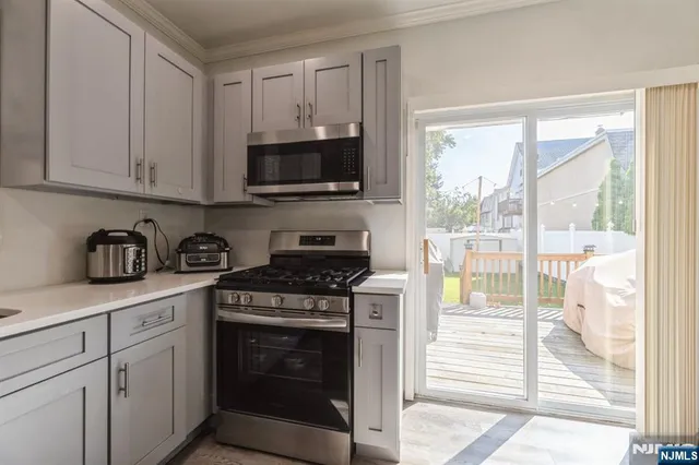 a kitchen with stainless steel appliances granite countertop a stove a sink and white cabinets