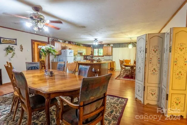 a dining room with wooden floor a chandelier a wooden table and chairs